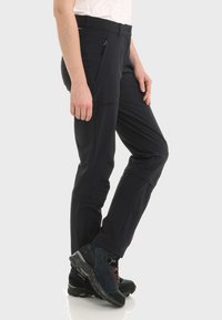 Schwarze Outdoor-Hosen für Herren aus elastischem Gewebe, mit seitlichen Reißverschlusstaschen, körperbetontem Schnitt und verstärkten Knien für zusätzliche Haltbarkeit.