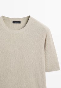 Pull beige côtelé à manches courtes avec encolure ronde et étiquette Massimo Dutti à l'intérieur du col.