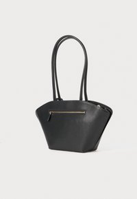 Mala de mão em pele sintética preta com um formato estruturado e angular. Apresenta duas alças longas e um bolso frontal com fecho de zip dourado.