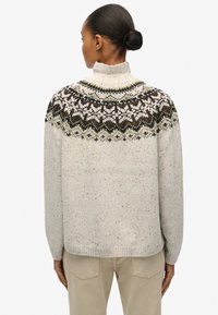 Gebreide trui in lichtgrijs met meerkleurig patroon bij het bovengedeelte, voorzien van een hoge kraag, lange mouwen en een losse pasvorm. Getextureerd oppervlak.