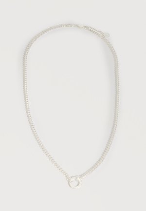 Ασημένιο κολιέ με αλυσίδα και κυκλικό μενταγιόν με χαραγμένο κείμενο, τοποθετημένο επίπεδα σε λευκό φόντο.