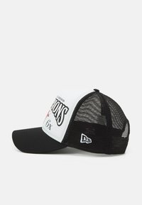 Zwart-witte pet met een gebogen klep, gaas achterkant en een gedurfde grafische print met tekst en accenten. Logo aan de zijkant.