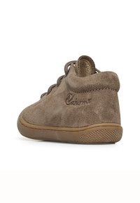 Stivale alla caviglia in suede marrone con suola in gomma flessibile, punta rotonda e chiusura con lacci marroni. Presenta un leggero marchio sul lato.