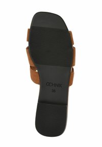 Brązowe zamszowe sandały z czarną gumową podeszwą, z teksturowanymi rowkami dla lepszej przyczepności i paskami. Rozmiar oznaczony jako 36.