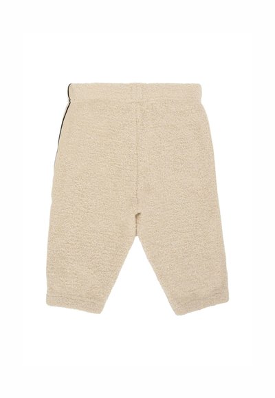 Beige, zacht aanvoelende fleece broek met een elastische tailleband. Gekropt met iets taps toelopende pijpen. Geen zichtbare patronen of hardware.
