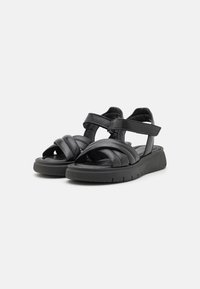 Zwarte leren sandalen met kruislings banden en verstelbare enkelbanden. Textuur-voetbed en rubberen zool voor grip en comfort.