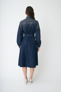 Τζιν φόρεμα σε σκούρο μπλε χρώμα με ζώνη στη μέση, μακριά μανίκια και μήκος μέχρι τη μέση της γάμπας. Διακοσμημένο με διάσπαρτο μοτίβο από μικρές λεπτομέρειες.