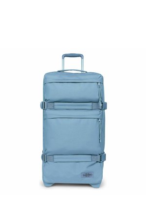 Pequeña maleta blanda azul con asa telescópica, bolsillos frontales con cremallera, correas laterales y logotipo de Eastpak sobre fondo blanco.