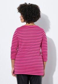 Maglietta a maniche lunghe a righe rosa e nere con scollatura arrotondata e spacchi laterali, realizzata in un morbido tessuto testurizzato.