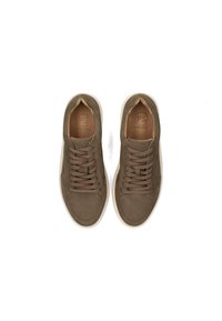 Baskets en suede marron avec orteils ronds, lacets plats et une semelle en caoutchouc de couleur claire. L'intérieur présente un logo en relief sur le cuir.