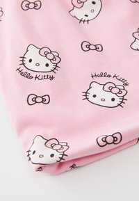 Tessuto rosa con illustrazioni ripetute di Hello Kitty con contorni neri e fiocchi. Il materiale sembra morbido e ha una texture liscia.