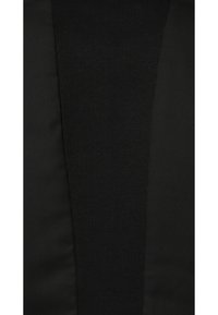 Tissu noir avec une texture côtelée à gauche et une finition lisse à droite, reliés par une couture. Le matériau semble léger et flexible.