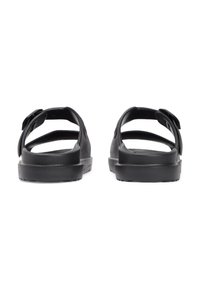 Μαύρα σανδάλια με ανοιχτή πλάτη, λεπτομέρειες με ιμάντες, επίπεδη σόλα από καουτσούκ και ματ φινίρισμα. Ελαφρύς σχεδιασμός, κατάλληλος για καθημερινή χρήση.