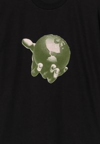 Camiseta negra con un gráfico de un globo terrestre estilizado en verde sostenido por una mano. El diseño presenta continentes detallados y sombras.
