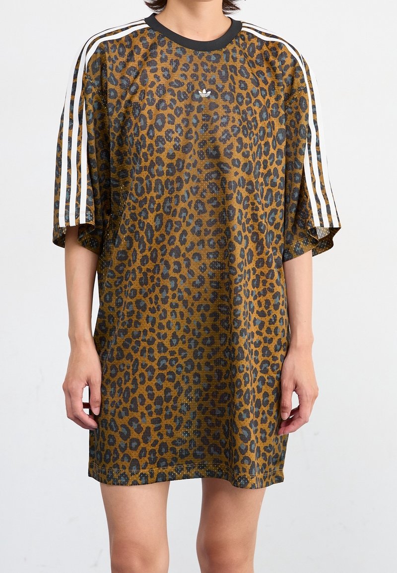 Överdimensionerad t-shirt klänning i leopardmönster i brunt och svart, med vita ränder på ärmarna och en rund svart halsringning.