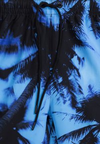 Niebieskie szorty kąpielowe z wzorem palm, wykonane z lekkiego materiału, z elastyczną talią i detalem sznurka w kolorze czarnym.