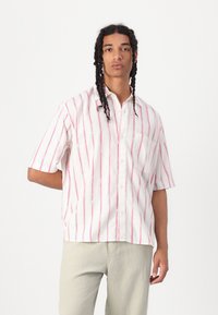 Short-sleeve button-up shirt in white with red and green vertical stripes, featuring a chest pocket and a relaxed fit. Cotton blend material.