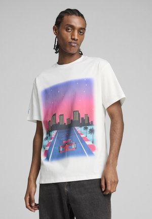 Wit katoenen t-shirt met een levendige grafiek van een stadsgezicht en raceauto, in tinten van roze en blauw, met palmbomen als accents.
