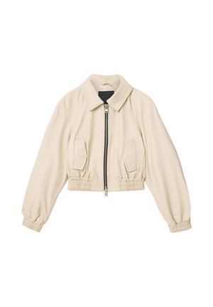 Kremfarvet kort jakke med lynlås foran, to klaplommer, elastisk talje og elastiske manchetter.