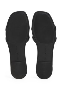 Suela de goma negra con superficie texturizada. Marca icónica visible. Bordes suaves y forma redondeada; diseñada para un uso casual.