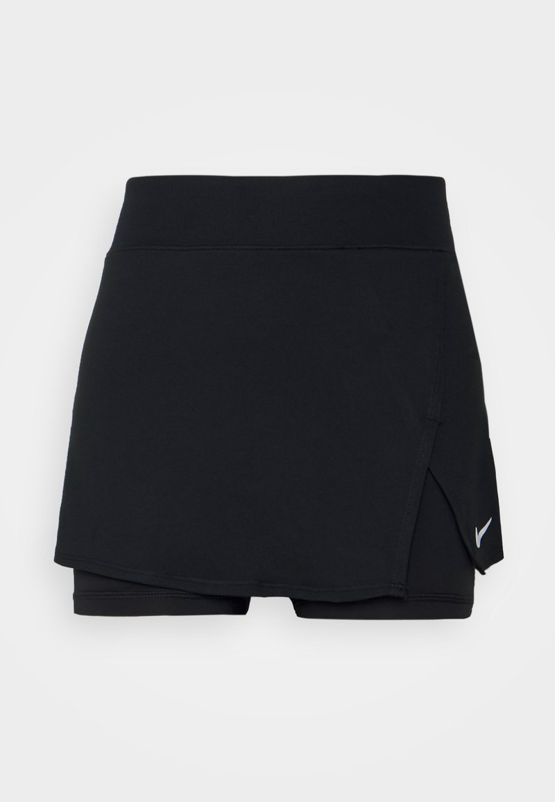 Skort de sport noir avec shorts intégrés, taille haute, détail de superposition latérale et petit logo Nike swoosh blanc en bas à droite.