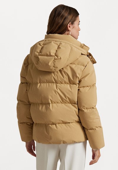 Een pufferjas in taupe met een capuchon, voorzien van gequiltte secties en een licht glanzende afwerking. Inclusief rits en knoopsluitingen.