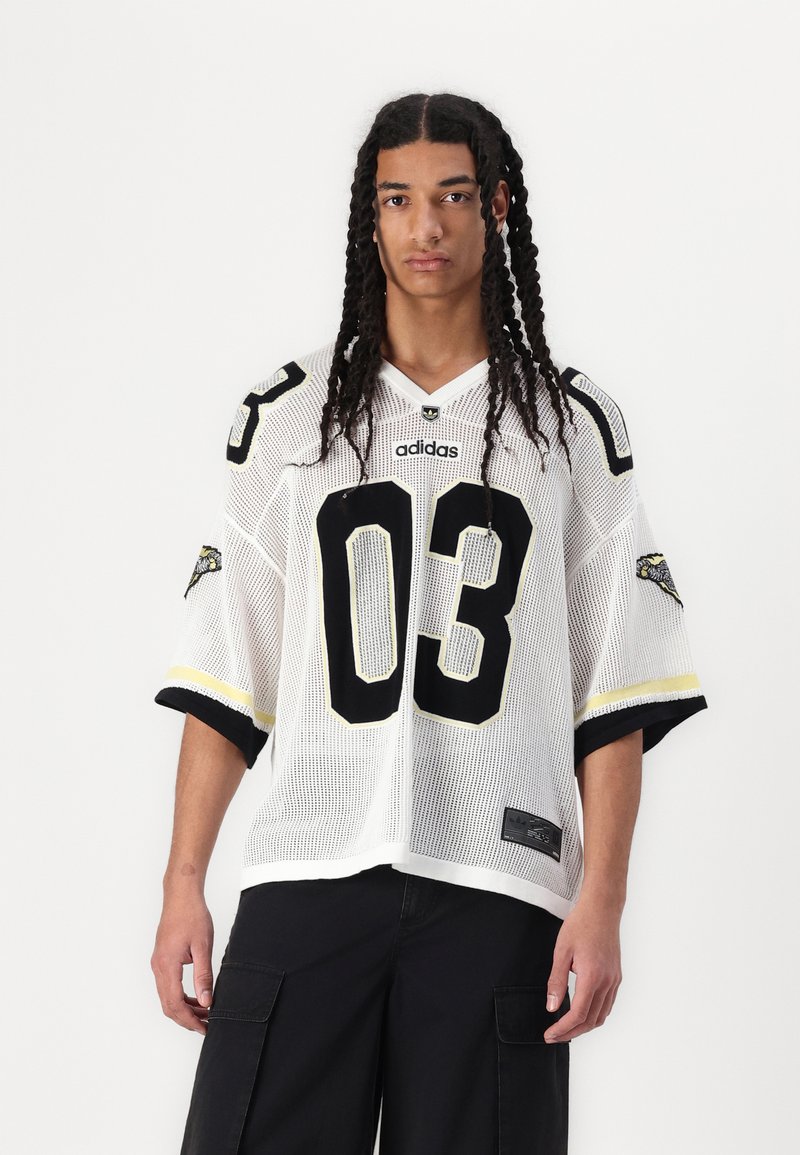 White mesh jersey with black accents and number 03. Features short sleeves, rounded neckline, and logo on the chest and sleeve. Black cargo pants.