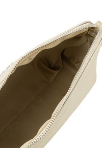Borsa in pelle beige con una zip argentata. L'interno è foderato con un tessuto liscio. Nessun motivo, design minimalista e forma compatta.