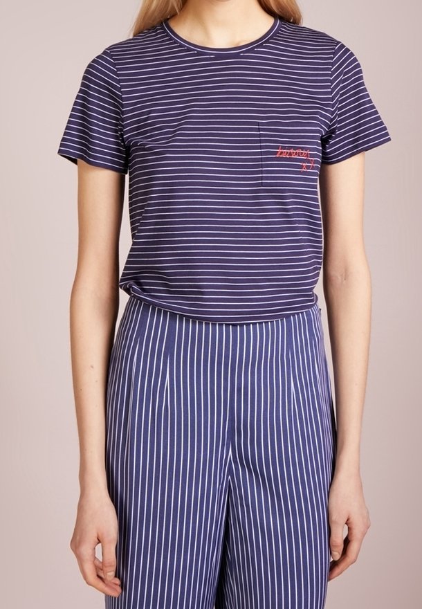 Námořnické modré pruhované tričko s krátkými rukávy a kulatým výstřihem, s malým červeným vyšitým detailem na kapsičce na prsou.