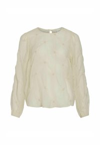 Jasno beżowa bluzka z długim rękawem o teksturowanej tkaninie, z okrągłym dekoltem i małymi dekoracyjnymi węzłami na całej powierzchni. Z tyłu otwarcie w kształcie łezki.