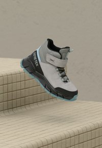 Sive in črne pohodniške čevlje GORE-TEX z visokim zgornjim delom, zavezovanjem na vezalke in teksturirano površino. Imajo turkizne poudarke in trpežen podplat.