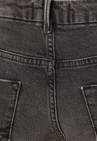 Zwarte denim jeans met een hoge taille, voorzien van een gladde textuur, stevige stiksels en klassieke achterzakken.