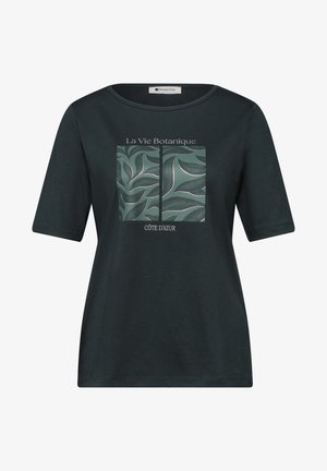 Sort kortærmet skjorte med et grønt botanisk bladdesign opdelt af en sort linje og teksten "La Vie Botanique" og "Côte d'Azur" foran.