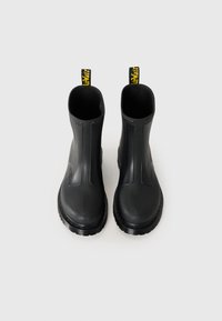 Μαύρες λάσπες κατασκευασμένες από καουτσούκ με λεία επιφάνεια, μέτριο ύψος, σόλα με υφή για καλύτερη πρόσφυση και κίτρινες λαβές στο πίσω μέρος για εύκολη φόρμα.