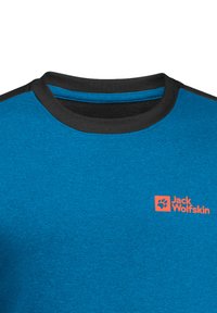 Camicetta blu a maniche corte con colletto nero, tessuto strutturato e logo arancione "Jack Wolfskin" sul petto.