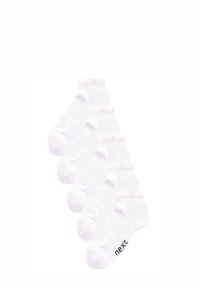 Öt pár fehér bokazokni elrendezve lépcsőzetesen, az egyik pár talpán "next" felirat található.