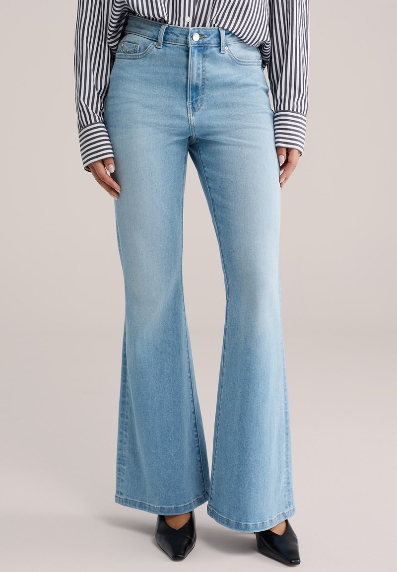 Hele sinised laienevad teksad teksariidest kõrge vöökohaga. Varustatud nööbi ja tõmblukuga, viie taskuga disainiga ning õrna pleekimisega reitel.