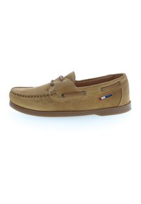 Mocasines de ante marrón claro con costura moc, detalle de cordón de cuero, suela de goma y pequeña bandera roja, blanca y azul en el lado.