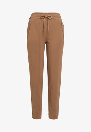 Brown tapered pants with drawstring waist and zippered side pockets, tailored seams, and ankle-length hem.