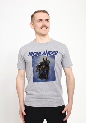 Grå bomulds t-shirt med et stort grafisk motiv af en karakter i rustning, med ordet "HIGHLANDER" i fed marineblå skrift ovenfor.