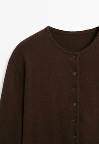 Brown knit cardigan with a round neckline, featuring a row of five dark buttons down the front and a soft, textured fabric.
