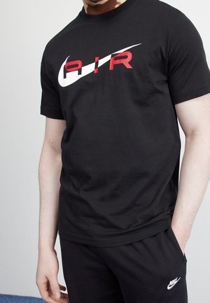 Camiseta de algodón negra con un gran gráfico en blanco y rojo que dice "AIR" en el pecho. Tiene mangas cortas y un diseño de cuello redondo.