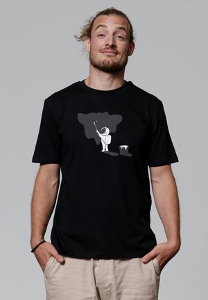 Zwart katoenen t-shirt met een afbeelding van een persoon in een ruimtepak die een sterry sky schildert, met een verfemmer naast zich.