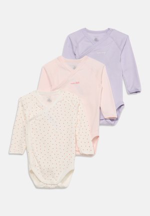 Tre langærmede babybodystockings i hvid med røde prikker, lyserød og lavendel, hver med viklefront og lille tekst på brystet.