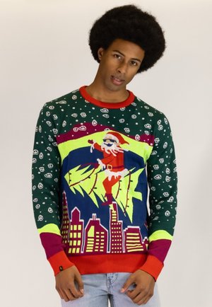 Grüner Strickpullover mit roten Akzenten, der ein Santa-Motiv, eine bunte Stadtsilhouette und Smiley-Gesichtsmuster aufweist. Entworfen für einen festlichen Look.