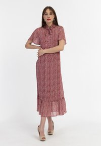 Rochie midi roșie cu flori, cu mâneci scurte, tiv ondulat și guler înalt. Fabricată dintr-un material ușor, cu o textură fluidă.