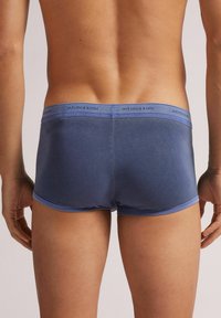 Herrens amningstrosor i mörkblå bomull med en ljusblå elastisk midjeband som har varumärket "intimissimi". Slät textur och figurnära design.