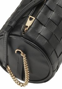 Borsa a tracolla in pelle nera con texture intrecciata, forma arrotondata, zip dorata e dettaglio a catena su una tracolla laterale.