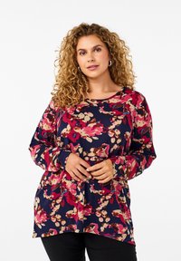 Maglietta a maniche lunghe di colore blu navy con un motivo floreale in rosa, crema e marrone. Tessuto morbido con una vestibilità rilassata e scollo rotondo.