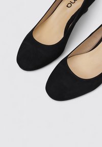 Ballerines en suede noir avec un bout arrondi et un intérieur lisse. Design minimaliste sans quincaillerie ni accents visibles.